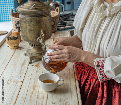 Wallpaper Mural Woman is pouring tea into a cup from a teapot Torontodigital.ca
