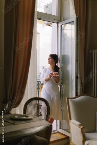Woman enjoying morning coffee on an open balcony