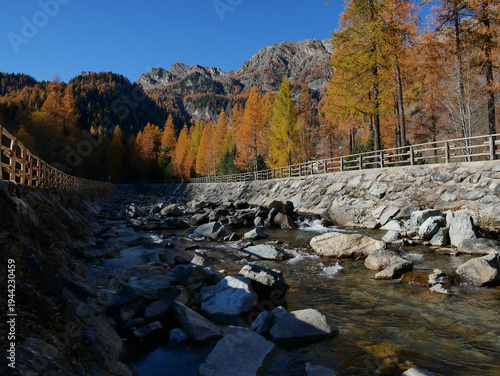 Autumn in the Alps. Chardonney, a hamlet of Champorcher, Aosta Valley, Alps, Italy. Along the river bottom.