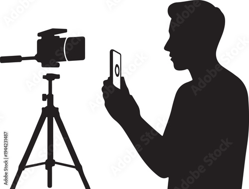 Silhouette of man filming with smartphone and camera on tripod