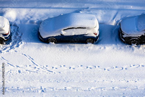 snow-covered parked cars on street after snowfall