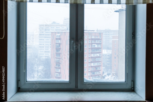 view through home window on apartment building