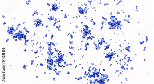 Vibrant blue confetti scattered on plain white surface