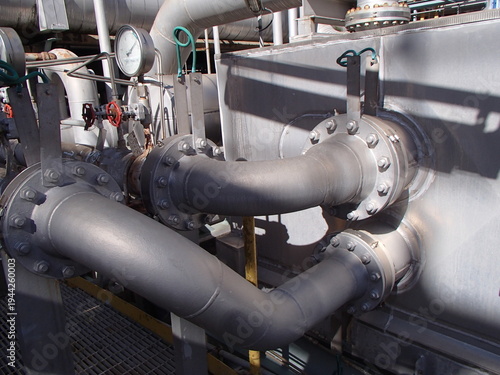 Schilderij op canvas Complex industrial piping system with steel flanges and pressure gauges in plant
