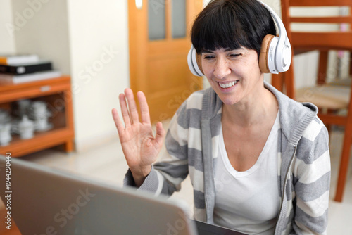 Foto Cheerful woman with headset interacts kindly with family through video chat sess