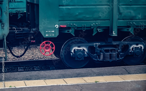 Schilderij op canvas Close-up of a train wheel and red valve on a railway track.