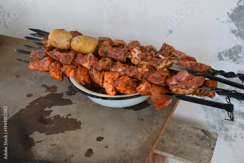 Pork shish kebab with potatoes on a metal skewer. Barbecue grilled chicken and pork on skewers with spices
