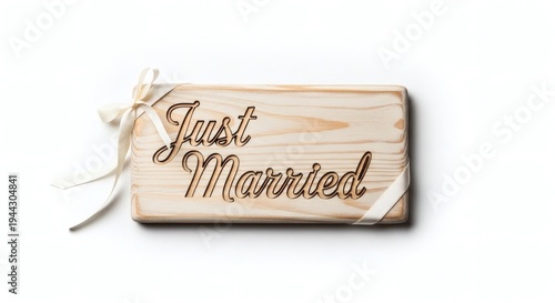 An elegant, engraved wooden sign announces Just Married, tied with delicate ribbons, symbolising a fresh start, love, and union.