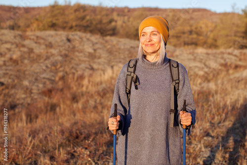 Canvas Print Attractive short haired middle aged woman in activewear hiking in forest using p
