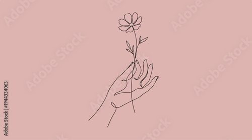 Delicate hand holding a single flower on a soft pink background.