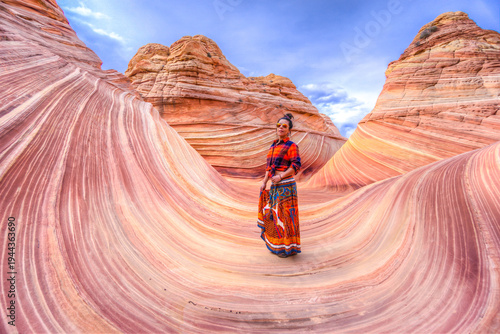 Foto A woman stands in front of a canyon with a plaid shirt and a skirt