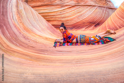 A woman is laying on a blanket in a canyon