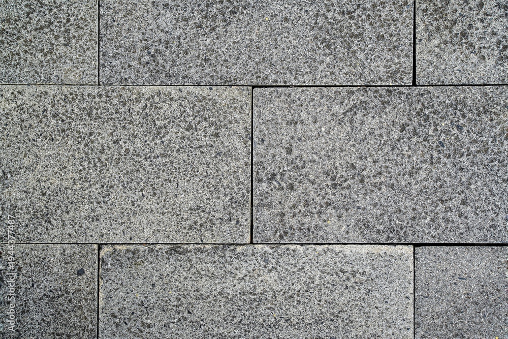 Fototapeta premium Grey textured rectangular stone wall background. Coarse granite texture. High-resolution grey granite stone tile texture background. Seamless basalt pavement blocks for architectural 3D rendering.