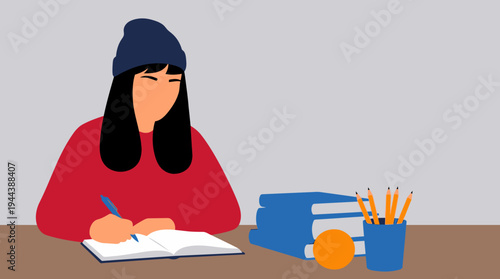 A young woman wearing a blue beanie and red sweater is diligently writing in a notebook at a desk with books and pencils.
