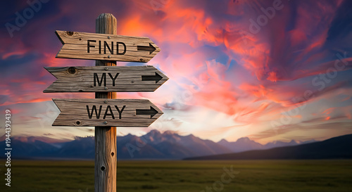 A wooden signpost with multiple arrows stands in a vast green field against a mountain range under a vibrant sunset sky with colorful clouds.