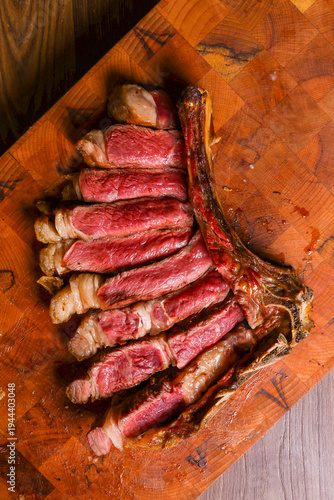 Bistecca di carne di manzo cotta sulla brace con cottura al sangue, scaloppata e servita su un tagliere di legno