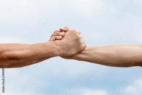 Rescue, helping gesture or hands. Strong hold. Close-up. Two hands, helping hand of a friend. Handshake, arms, friendship. Friendly handshake, friends greeting, teamwork friendship