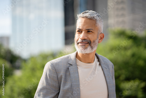 Schilderij op canvas Mature professional man with gray beard in blazer standing outdoors with modern
