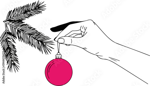 Hand holding a pink bauble to decorate a fir tree branch