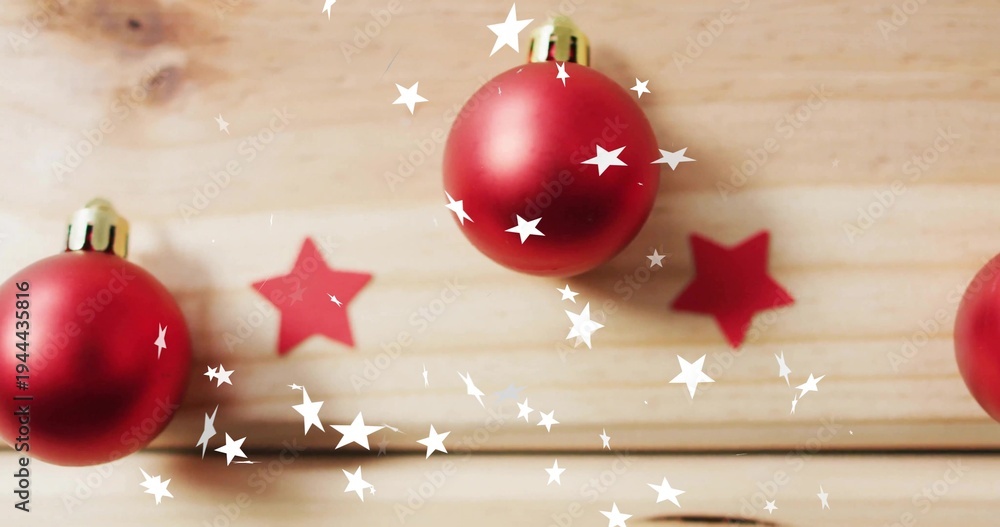 Fototapeta premium Displaying three red baubles with gold caps on wooden planks, showing red stars and white bokeh