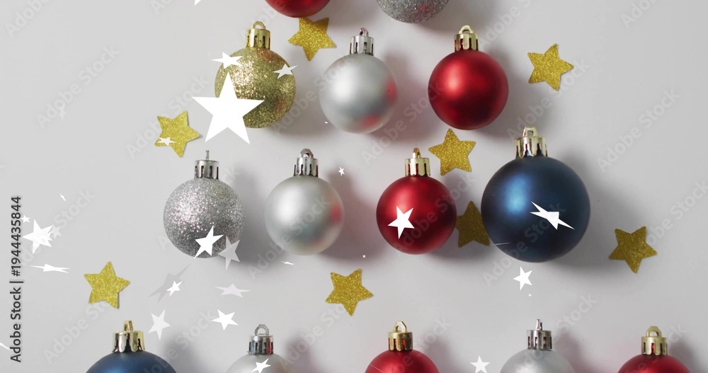 Obraz premium Displaying centered holiday baubles forming tree on gray surface with metal caps and gold stars