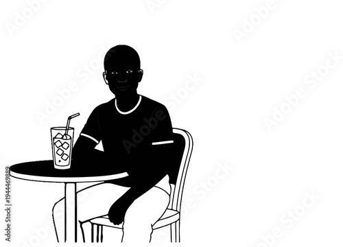 Person sitting at a table with a drink