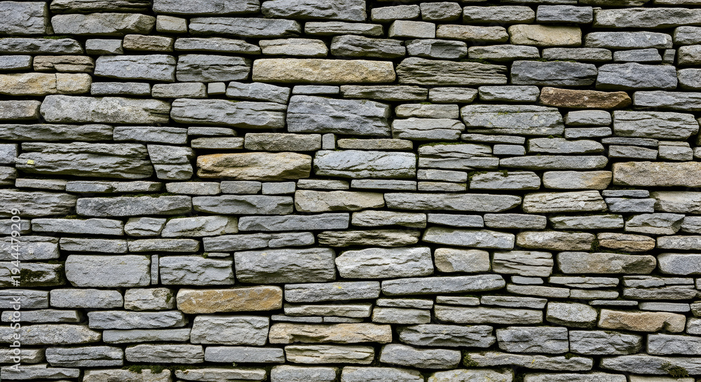 Obraz premium A close-up view of a stone wall with various grey and brown stones.