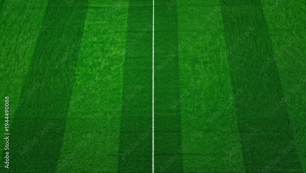 Fototapeta premium Showing top-down aerial view featuring white painted center line on sports field, striped turf