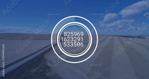 Ringed HUD appearing then cycling numeric readouts for targeting while overlaying canal, sand