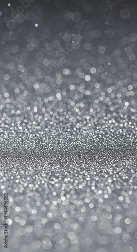 Ethereal abstract texture showing a subtle glimmering light pattern. Defocused tiny specks of silver light create a festive background, glowing, defocused, illuminated