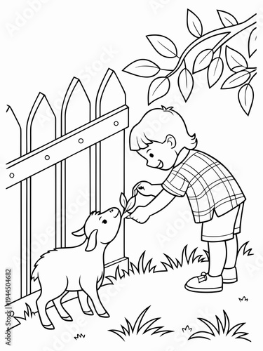 A boy feeds a little goat through a fence