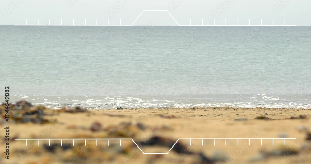 Obraz premium Showing sandy shore with pebbles and seaweed meeting calm surf at water's edge, with HUD overlay
