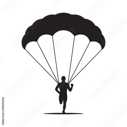 A silhouetted skydiver descending with a fully open parachute above ground