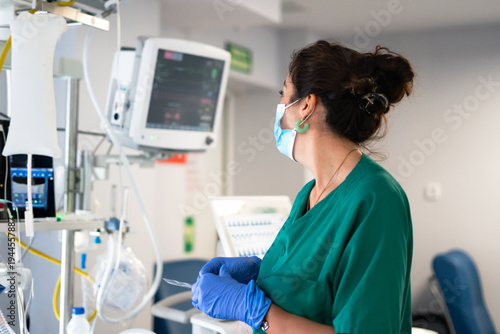 Nurse monitoring vital signs in intensive care unit