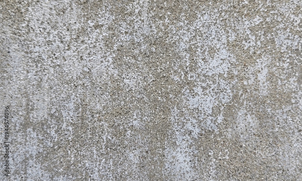 Obraz premium Colorful stains under crumbling gray paint on shabby wall of grungy building on street.Old concrete background for wallpaper.Texture of old dirty Rough Peeled concrete wall for scratched Background.