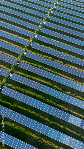Aerial view of repeating solar panel rows forming geometric pattern in large solar farm