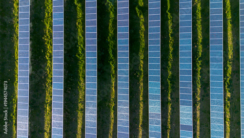 Aerial view of repeating solar panel rows forming geometric pattern in large solar farm