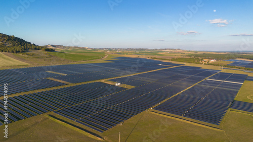 Aerial view of large solar farm with rows of photovoltaic panels producing renewable energy