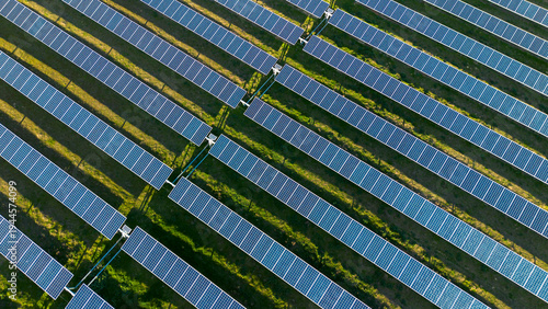 Aerial view of repeating solar panel rows forming geometric pattern in large solar farm
