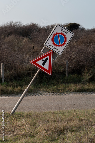 Leaning dutch road signs showing a no parking zone