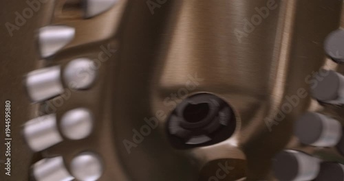 The drilling rig is working. The drill head is rotating. Close-up handheld shot, real time speed, artificial lighting. Abstract industrial background.