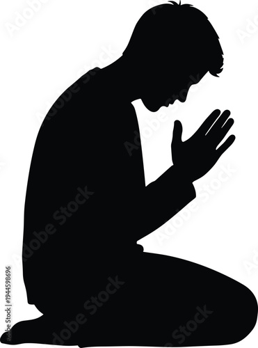 Silhouette of a young man kneeling in prayer and meditation with folded hands seeking peace, spirituality, and divine guidance alone.
