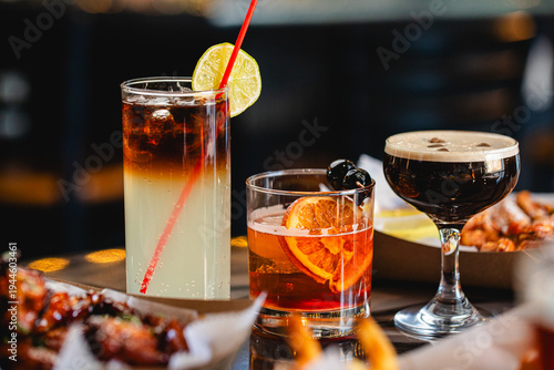 Dark and Stormy, Manhattan, Espresso Martini served together on a table at a modern restaurant and bar
