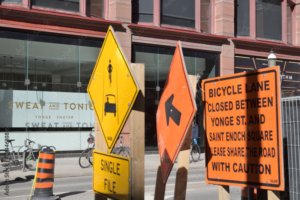 Naklejka premium sign at Sweat and Tonic, a fitness centre, located at 225 Yonge St, Floor 1 of The Ryrie Building, incl defocused construction signs, Toronto