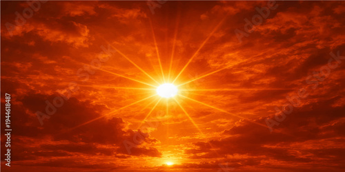 A beautiful orange sunset glows through a dramatic cloudscape as sunlight paints the sky with fire and gold during a vibrant nature landscape at dusk