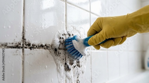 Scrubbing mold spots on ceiling paint black mold in tile grout with a brush, a photo for bathroom hygiene and home repair guides.