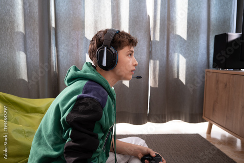 Teenager Sitting on Floor Playing Video Games at Home, close up