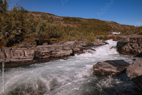 Fast Flowing Mountain River with Rapids and Rocky Banks in Northern Landscape
