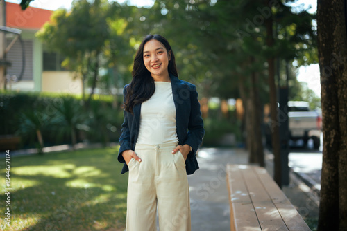 Young Asian woman smiling standing outdoors looking confident