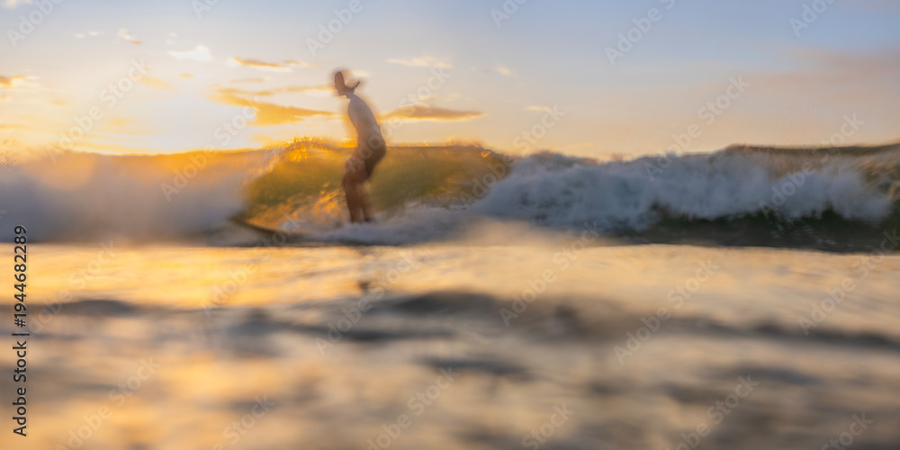 Fototapeta premium Abstract surfer riding a wave long exposure panorama
